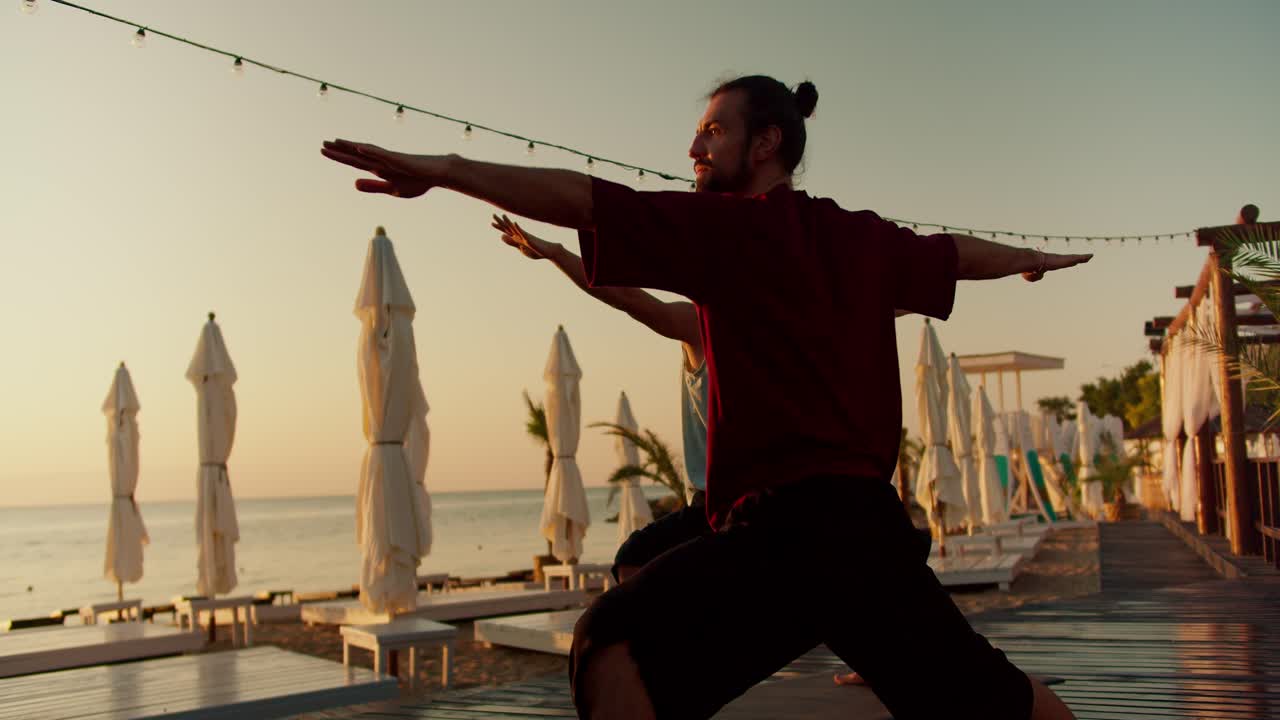 두 남자가 명상과 요가의 자세를 취했습니다. 팔을  ⁇ 으로 펴고 - 해가 뜨면 명상합니다. 젠