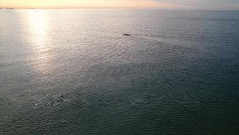 Hombre-Solitario-Nadando-En-Un-Mar-Al-Amanecer-Temprano-Por-La-Mañana---Antena-En-Lo-Alto