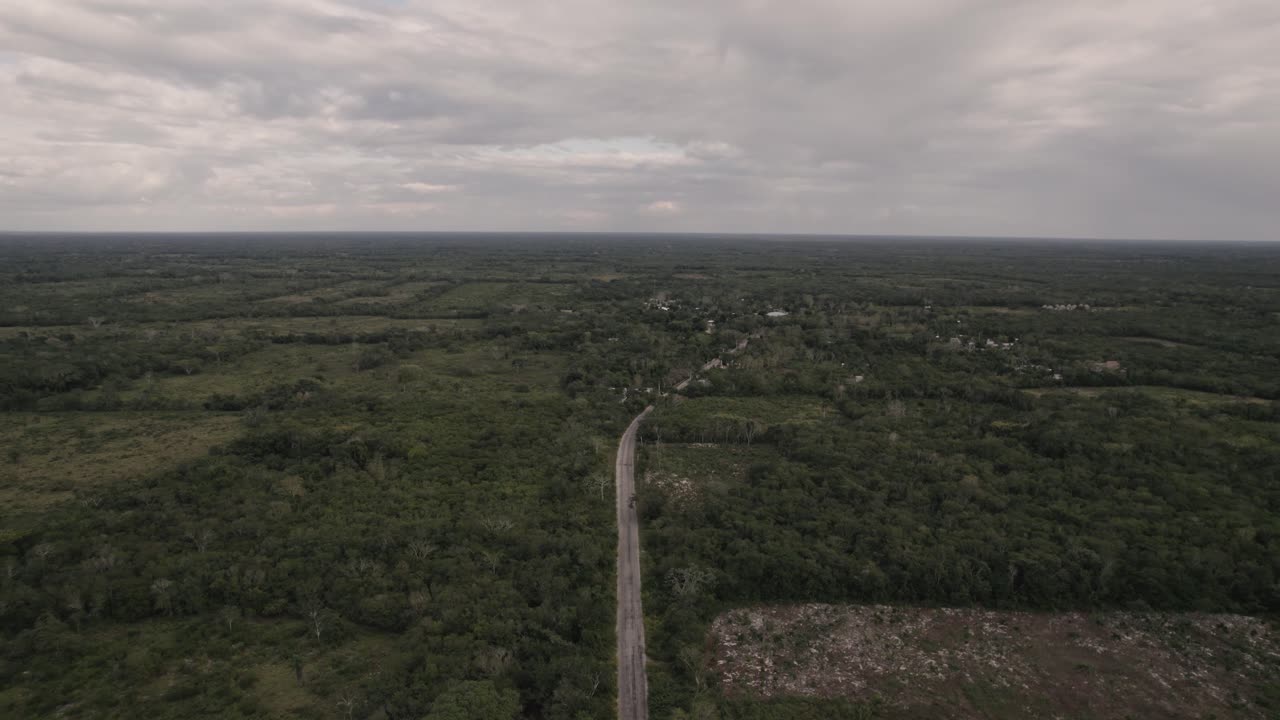 vasto paisaje verde con camino angosto que se dirige a un pequeño pueblo en méxico