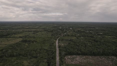 vasto paisaje verde con camino angosto que se dirige a un pequeño pueblo en méxico