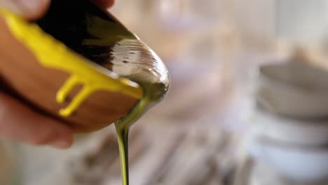 Female-potter-pouring-paint-into-bowl