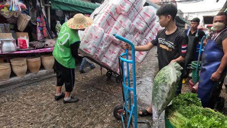 team unloads sacks of goods at a busy market