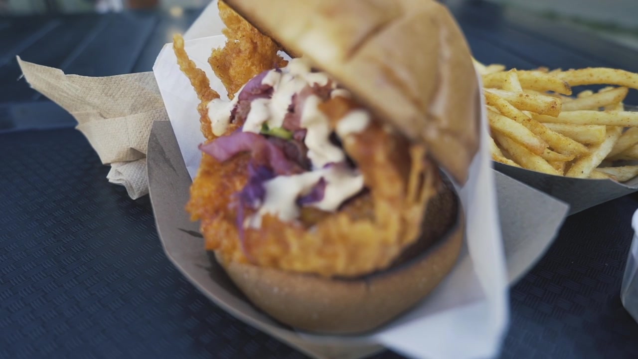 Un delizioso sandwich al pollo con patatine fritte in un ristorante di San Jose, California, in un fresco pomeriggio di primavera