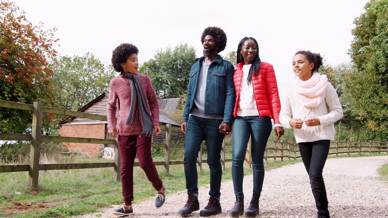 Mixed race family walking together on a countryside, children running ahead of their parents, low angle