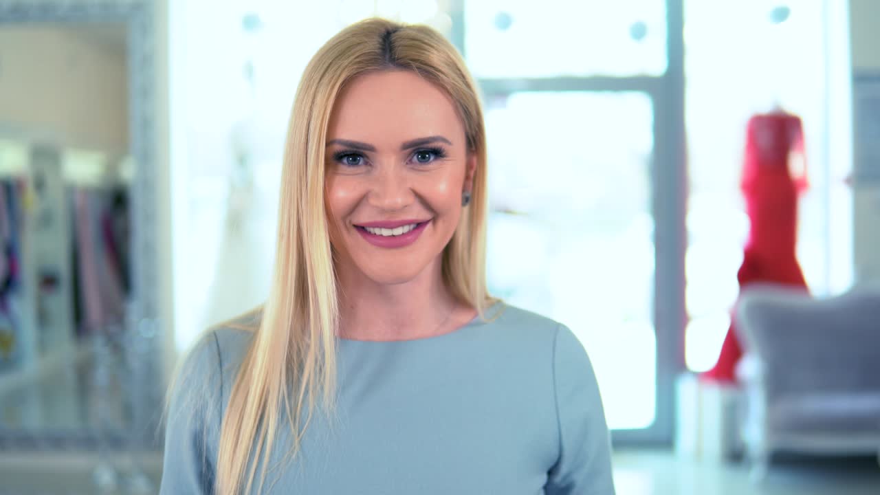 una mujer rubia feliz comprando un artículo en la caja registradora en una boutique de lujo.