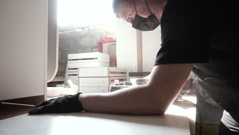 carpintero lijando madera en el taller