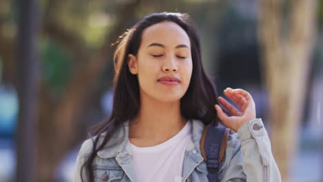 Portrait-of-asian-woman-touching-her-hair-and-smiling