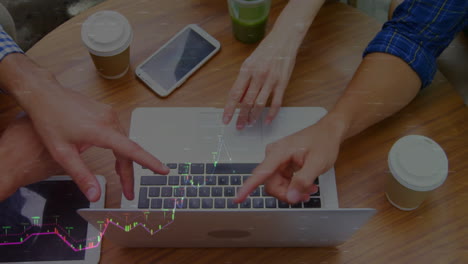 pointing at laptop keyboard, hands over stock market data animation