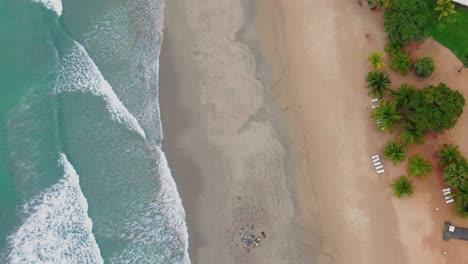 aerial, rising, top down, birdseye, drone shot of waves hitting a paradise beach, birds fly around looking for food, near trincomalee, on a cloudy day, in gokanna, in the eastern province of sri lanka