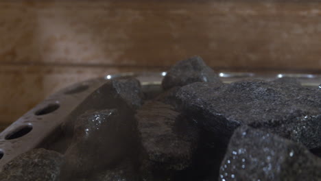 Verter-Agua-Sobre-Rocas-De-Sauna-Calientes-Para-Generar-Vapor-Dentro-De-La-Sauna