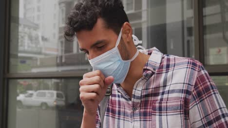 vista lateral de un hombre caucásico que lleva una máscara de corovirus covid19 y tose