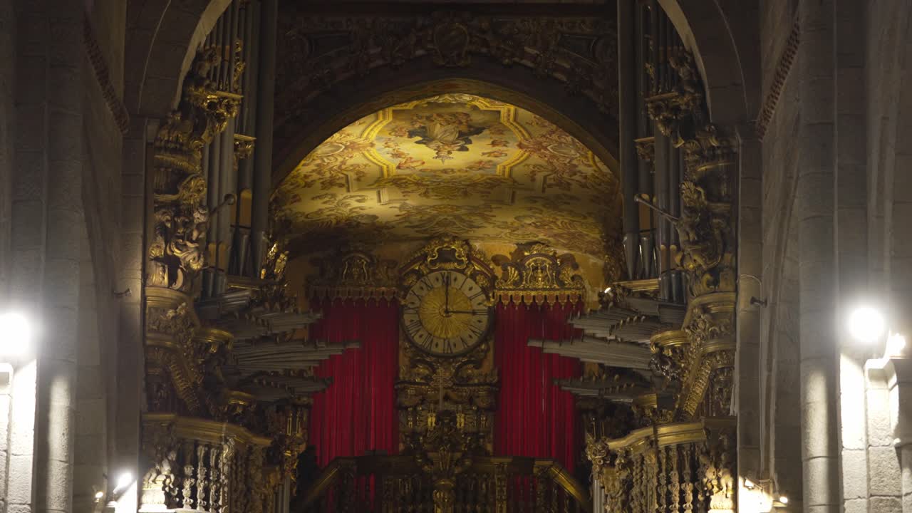 Opulent interior of Sé de Braga with ornate golden carvings, red drapery, and intricate details