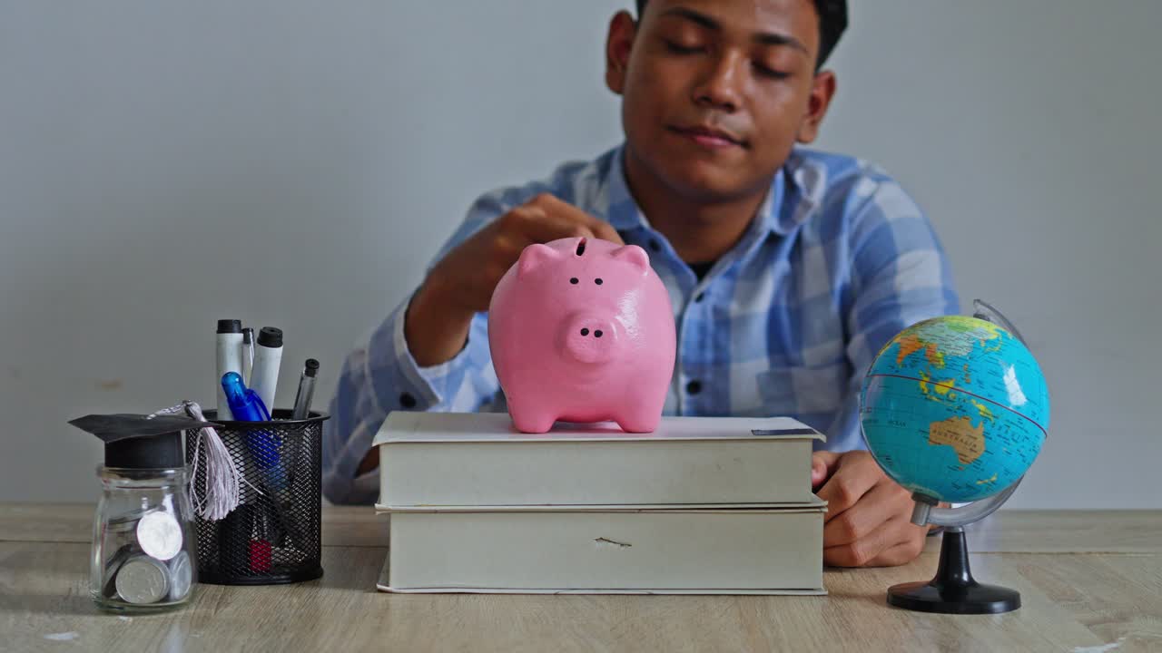 Close-up of person investing in their future by adding coins to bank