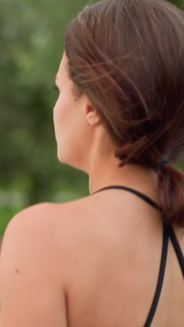 side view of woman jogging in fitness wear with neatly tied hair, enjoying outdoor exercise in park, fitness enthusiast engaged in healthy workout routine in nature, focused on health