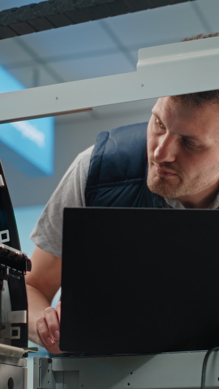 Technician repairing printer with laptop