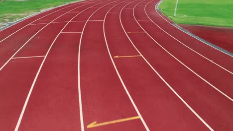 running track at the stadium, color is orange brick, high angle view by drone.