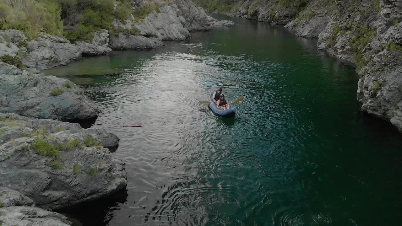 Persone in tour in kayak che remano in barche attraverso il canyon sul fiume Pelorus, Nuova Zelanda, con foresta nativa e massi di roccia - Drone Aereo.