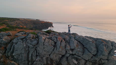 traveler taking picture sunset ocean. sea waves reflecting sun. marine nature