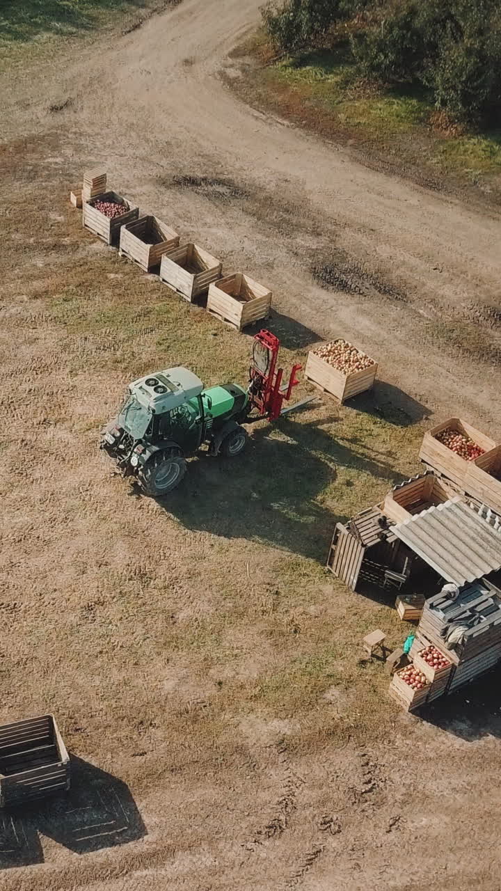 Tractor working on the farm. Aerial view of agricultural transport working in the field Vertical video
