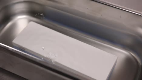 piedra de afilar en un baño de agua