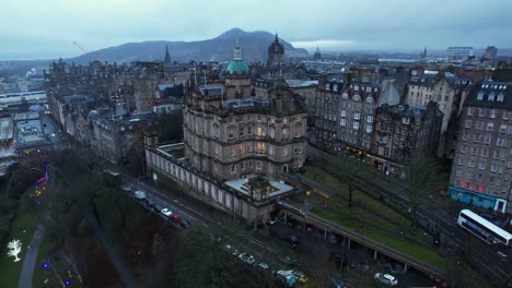 old buildings in edinburgh, with holyrood park in the background, 4k aerial view