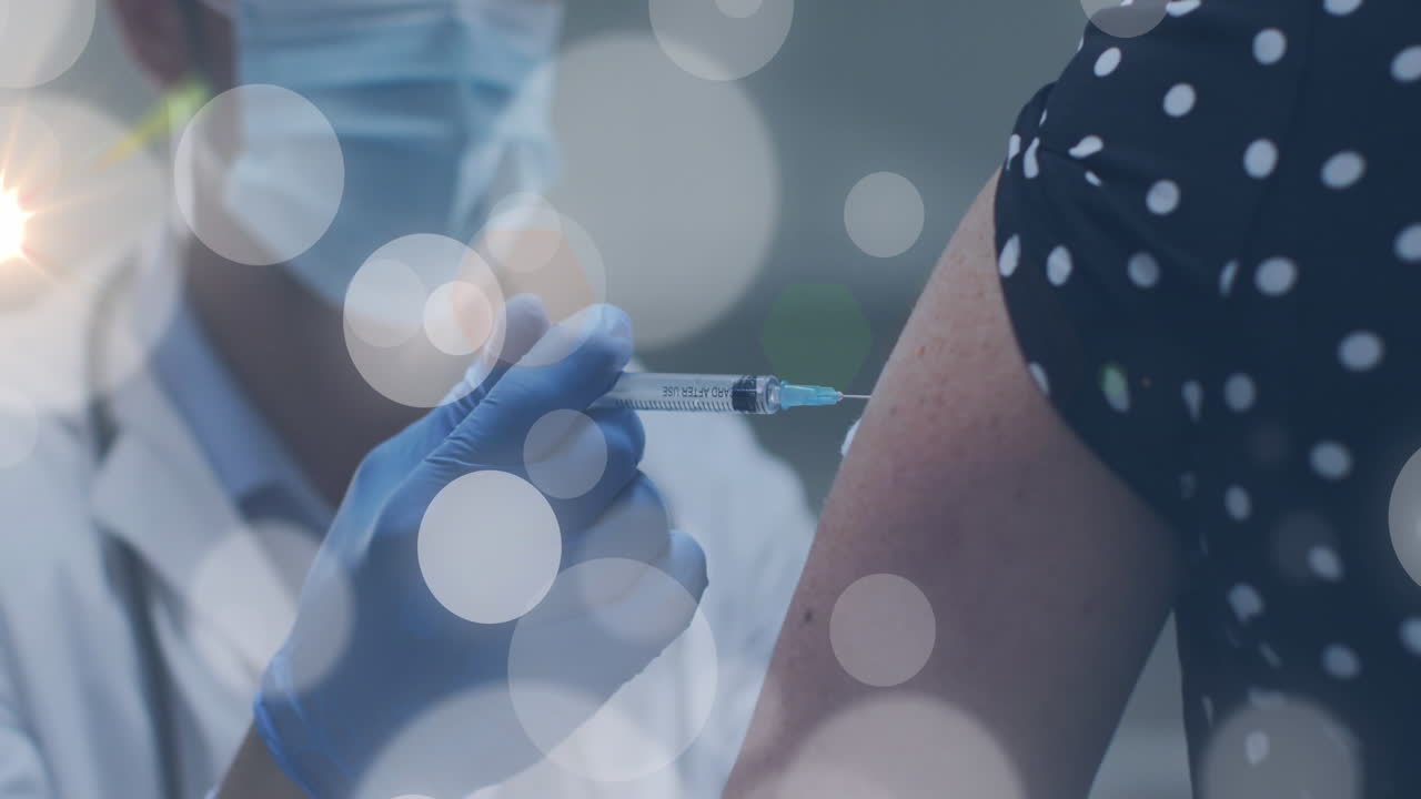 Animation of light spots over diverse doctor and patient vaccinating