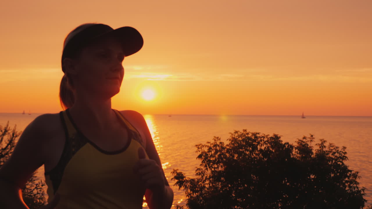 молодая женщина бежит в живописном месте на берегу моря, где солнце садится за воду