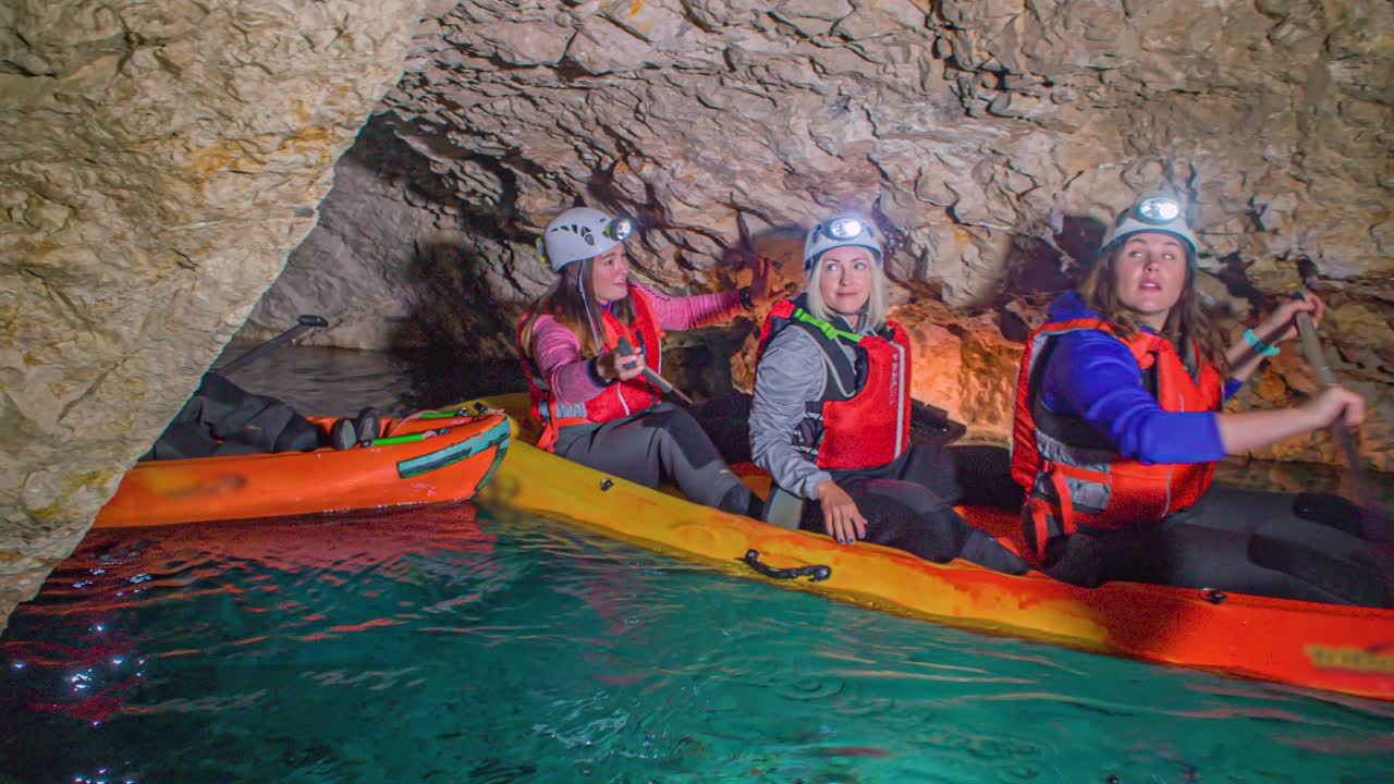Friends rowing kayak and enjoying the view of underground mines at mining museum in Glančnik in Mežica. Side view