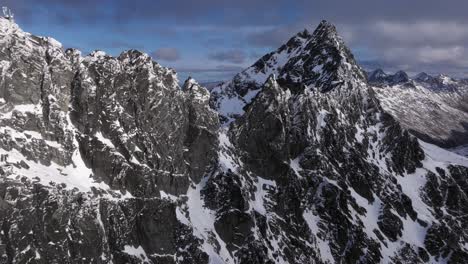 wild rocky and snowy mountains on beautiful day with blue skies and rolling clouds