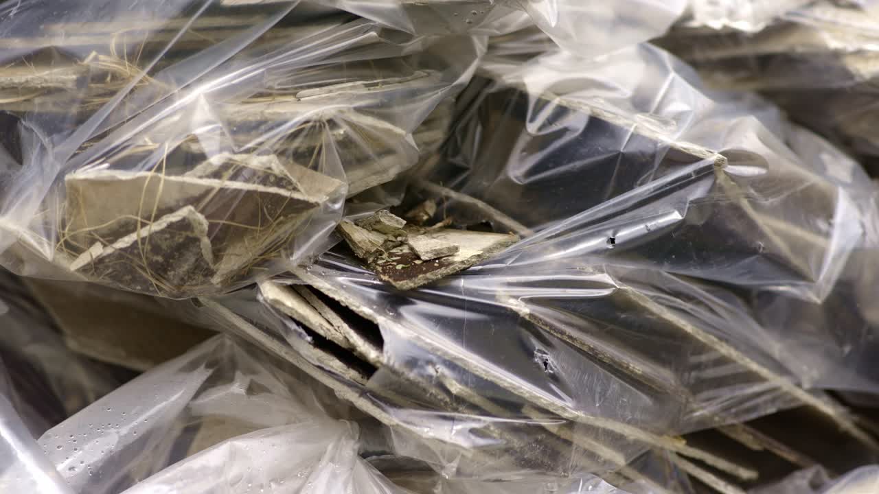 Pieces of asbestos material in plastic bags, poking through