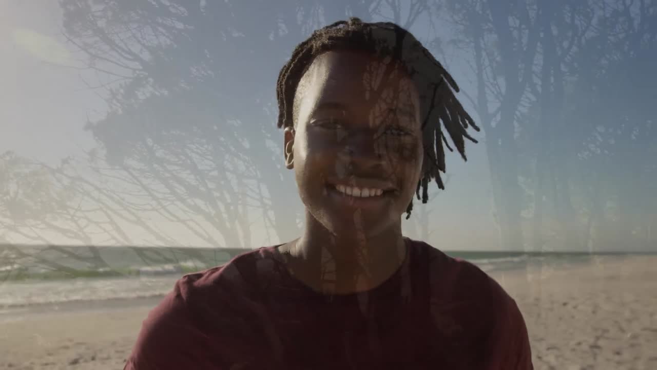 Animation of tree over african american man smiling