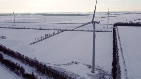 Vista-Aérea-De-La-Pala-De-La-Turbina-Eólica-Gira-En-Un-Pintoresco-Paisaje-Nevado-De-Invierno