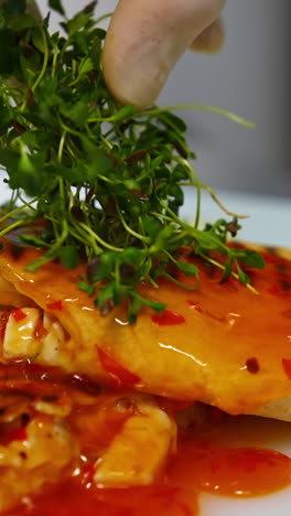 delicious pita poured with sauce. cook decorates a dish with green sprouts. before serving a meal, the chef of the restaurant completes the decoration.close-up. vertical video