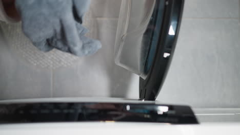 a woman opens the door of a washing machine