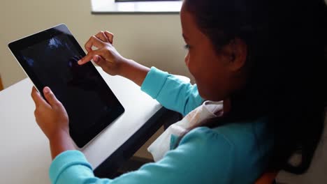 Schoolgirl-using-digital-tablet-in-classroom-at-school