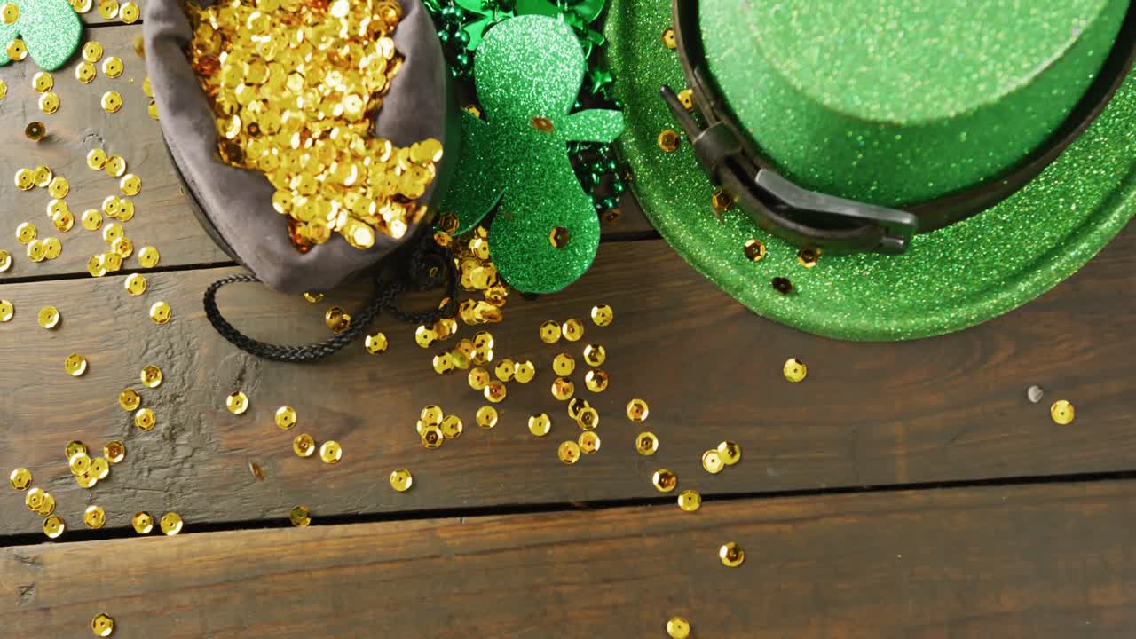 Video of st patrick's green hat, shamrock and gold sequins on wooden background