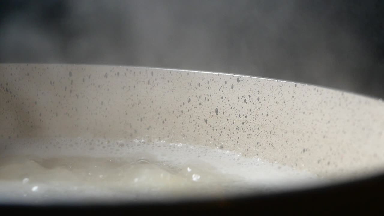 Close-up of Water Boiling and Steaming in a Pot