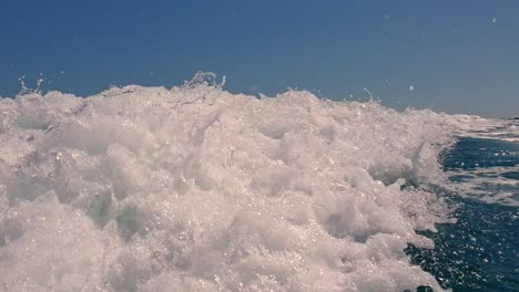 Punto-De-Vista-De-ángulo-Bajo-De-Salpicaduras-De-Agua-En-La-Superficie-Del-Mar-Detrás-De-Lancha-Rápida