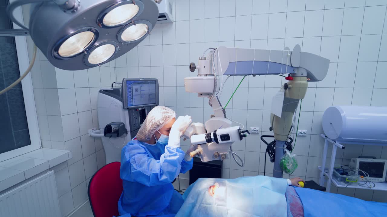 Patient under surgical microscope. Patient and surgeon in the operating room during ophthalmic surgery