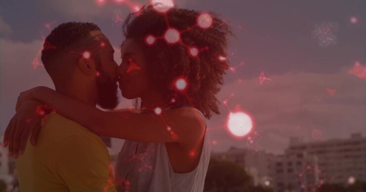 Couple enlacé au bord de l'eau au coucher du soleil, l'étreinte générant un effet bokeh rouge pour le marketing.