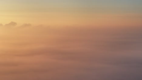 sunrise drone view panning right to left above golden winter fog