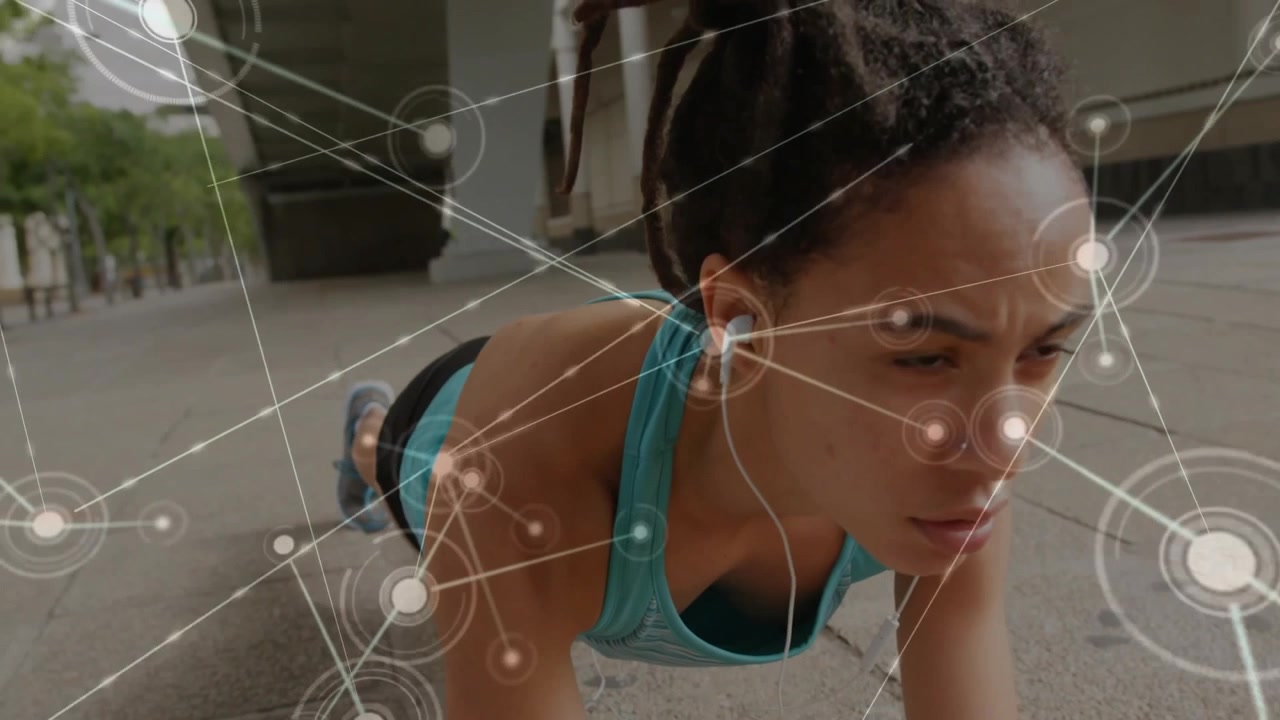 woman doing plank exercise on walkway wearing earbuds featuring fitness network overlay graphics