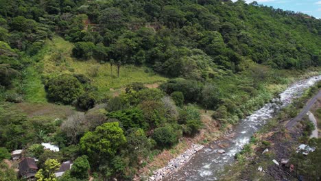 drone shot of caldera river and green hillside forest in landscape of boquete, panama