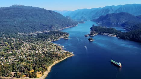 helicopter pov of deep cove and indian arm and belcarra park in north vancouver and coquitlam bc canada - aerial handheld view of ocean and mountains with boats on a sunny summer day