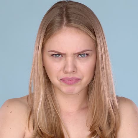 angry young female  blond hair with bare shoulders  frustrated emotions on her face