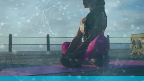 animation of network of connections over woman meditating on promenade by the sea