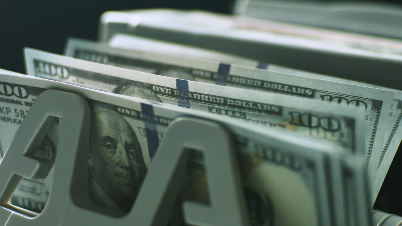 billetes de cien dólares en un clasificador de billetes