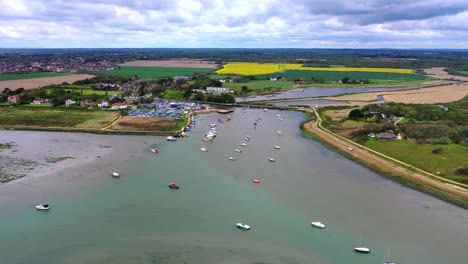 Drone-flying-over-the-sea-during-Summer,-zooming-in-on-a-dock,-where-some-boats-are-out