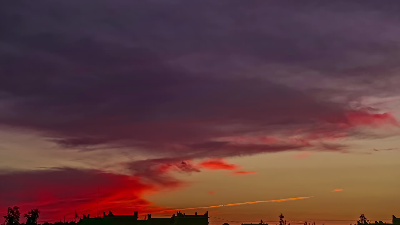 tiro de lapso de tiempo de nubes de color rojo volando en el cielo después de la puesta de sol dorada