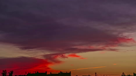 tiro de lapso de tiempo de nubes de color rojo volando en el cielo después de la puesta de sol dorada